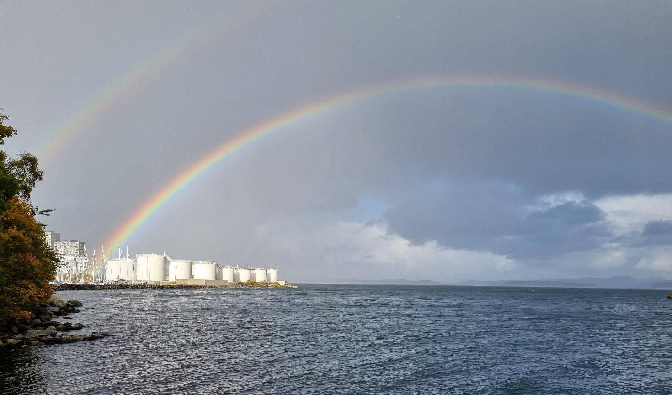 Tankanlegg i Rogaland Foto: Tonje F. Aase. Bilde av lagringstanker som ligger ved sjøkanten og har dobbel regnbue